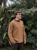 Sweater azul marino de lana con cuello redondo y logo bordado en rojo en el pecho. Corte holgado.