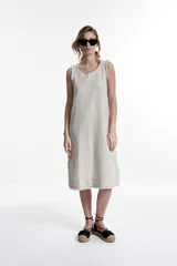 Vestido midi sin mangas, color beige melange, de corte recto y holgado, con terminaciones deshilachadas en el cuello y el ruedo.