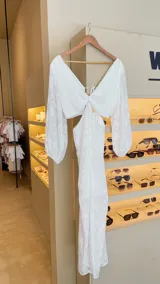 Vestido largo blanco de crepé transparente con labrado opaco, mangas largas abullonadas, aro central en el busto, falda en capas y espalda autorregulable.