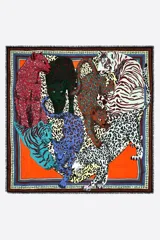 Chal de modal con diseño estampado de felpos de colores y fondo naranja, bordes decorados con cenefas geométricas y flecos cortos en los extremos.