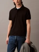 Chomba negra de manga corta con cuello polo y tapeta de tres botones. Monograma de Calvin Klein bordado en el pecho. Corte regular.