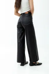 Pantalón de cuero sintético negro, de corte ancho y tiro alto.