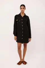 Vestido camisero corto color borgoña de lino italiano, con cuello camisero, manga larga, cierre frontal con botones y dos bolsillos de parche en el pecho con bordado de cerezas.