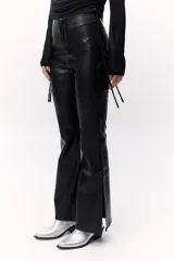 Pantalón acampanado de cuero sintético negro con textura símil piel de serpiente y tajos laterales en el ruedo.