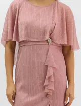 Vestido midi de tejido metalizado color turquesa, con sobrecapa de tul liviano sobre los hombros, detalle de pedrería en la cintura, volado lateral y tajo frontal.