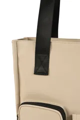 Bolso tipo tote color beige con doble asa superior negra y correa ajustable. Presenta un diseño estructurado con dos bolsillos frontales funcionales, uno con cierre y otro con solapa y broches a presión.