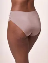 Bombacha tipo vedetina con paneles laterales de encaje bicolor y centro de microfibra brillante. Presenta un pequeño aplique de perla en la parte frontal y bordes festoneados.