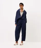 Pantalón de poliamida color azul marino, con diseño barrel de piernas anchas, cintura estructurada con pasacintos y pinzas frontales. Cuenta con botamanga levemente ajustada.