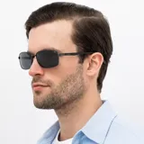 Lentes de sol INVU modelo IB12409A, con montura rectangular de metal color negro y gris plomo, y lentes polarizadas.