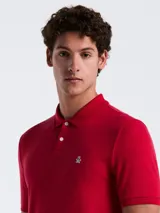 Polo roja de piqué de algodón orgánico, corte recto, cuello con solapa y logo bordado en el pecho.