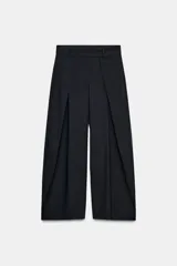 Pantalón de tiro medio color azul marino, con cintura con trabillas y detalle de pinzas en el delantero. Tiene pierna ancha y cierre frontal con cremallera, botón y ganchos metálicos.