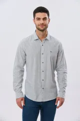 Camisa de lino rayada de manga larga, con cuello camisero, cierre frontal de botones y bordado sutil en el pecho.