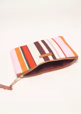 Sobre de algodón a rayas verticales de colores naranja, rosa, marrón, rojo y blanco. Tiene cierre superior con cremallera y tira de cuero marrón para la muñeca.