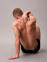 Pack de 5 bóxers tipo slip de algodón en colores negro, gris, rojo y blanco. Todos los bóxers tienen cintura elástica con el logo de Calvin Klein repetido.