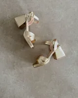 Sandalias de cuero color bronce, con taco cuadrado y tiras cruzadas en el empeine.