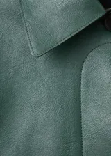 Chaqueta corta de efecto piel en color verde, con cuello de solapa, cierre frontal de botones y dos bolsillos de parche con solapa en la parte delantera.