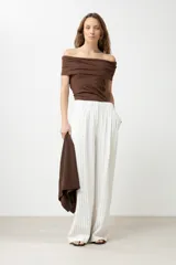 Remera de color marrón con escote bardot, diseño ajustado al cuerpo y mangas cortas.