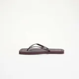 Chanclas de dedo color bordó con suela plana y tiras finas texturizadas.