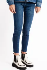 Botinetas de cuero vacuno color blanco tiza, con elásticos laterales negros, suela de goma antideslizante y plataforma con taco cuadrado.