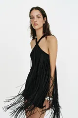 Vestido mini negro con cuello halter y diseño completamente cubierto de flecos a tono.
