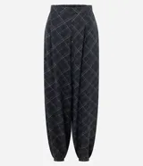 Pantalón estilo aladino de viscosa con estampado de cuadros. Presenta cintura elástica, corte holgado con volumen tipo globo y puños ajustados en los tobillos.
