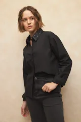 Camisa negra de algodón con cuello clásico y tachas plateadas.