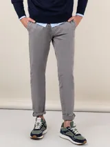 Pantalón chino gris de gabardina con corte slim fit, bolsillos delanteros y traseros. Lavado final con enzima ácida para un aspecto desgastado.