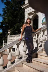 Mono largo de tul negro semitransparente, con aplicaciones espejadas brillantes en toda la prenda, de corte recto y tirantes finos.