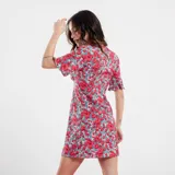 Vestido corto con estampado floral en tonos rojos y celestes, con escote en V y mangas cortas acampanadas.
