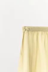 Shorts de tiro medio confeccionados en tejido georgette color amarillo suave, con cintura elástica y aplicaciones de encaje en los laterales del bajo.