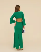 Vestido largo color verde esmeralda, con escote en V, corte a la cintura y falda con abertura lateral. Mangas largas acampanadas y espalda descubierta.