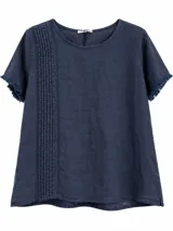Blusa azul marino de manga corta, con cuello redondo y detalles de alforzas y bordados en el frente, además de flecos sutiles en las mangas.