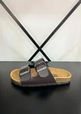 Sandalias de tiras de ecocuero marrón con dos hebillas metálicas ajustables y plantilla anatómica.