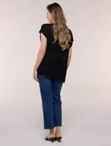 Blusa negra de tejido de punto fino con hilos de lúrex brillante, escote redondo amplio, mangas cortas con hombros caídos y silueta semi holgada.
