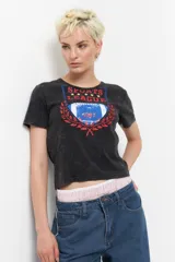 Remera negra de manga corta con estampa de escudo con la inscripción "Sports League" y una pelota de fútbol americano.