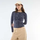 Camiseta de manga larga en tejido de punto acanalado color azul marino con estampado floral pequeño en tonos rosados. Presenta cuello redondo con cierre frontal de botones tipo henley.