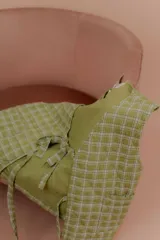 Chaleco verde claro con diseño acolchado y estampado a cuadros, sin mangas y con tiras para anudar en el frente.