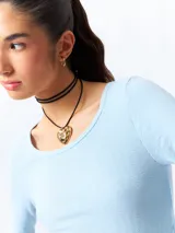 Remera blanca de algodón, de manga larga y cuello redondo.