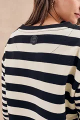 Sweater de punto a rayas horizontales anchas en color negro y crudo, de corte oversize, mangas largas y cuello redondo.