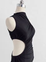 Vestido midi negro con diseño drapeado, cuello alto, abertura lateral en la cintura (cut-out) y un solo hombro descubierto.