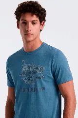 Remera celeste con estampado frontal en tonos oscuros que incluye elementos de juegos de azar como cartas, dados, fichas y un vaso, acompañado del texto "BOTTOMS UP!".