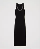 Vestido largo negro de tejido de punto con cuello redondo y espalda descubierta con borde de lentejuelas. Tiene tirantes anchos, abertura lateral y corte ajustado.