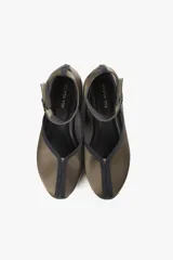 Zapato negro con base deportiva y pulsera al tobillo ajustable. Parte superior de tela satinada, forro y plantilla de piel de cerdo y suela de goma.