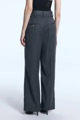 Pantalón sastrero de tiro alto con diseño rayado y fit amplio. Presenta una doble cintura con detalle descosido, pinzas delanteras y traseras, y bolsillos ojal en la parte posterior.