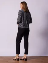 Blusa de gasa estampada con líneas verticales negras sobre fondo beige, de manga larga con puño abotonado. Espalda con abertura y botón.