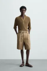 Polo manga corta color marrón, de punto con 17% de lino y cuello solapa con abertura frontal.