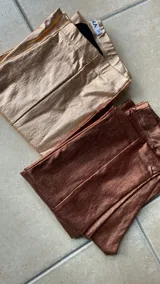 Pantalón negro de tiro alto, corte ajustado y confeccionado en gabardina elastizada con acabado metalizado.