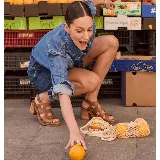 Sandalias de cuero color marrón, con taco ancho, diseño de tiras cruzadas y hebilla metálica de ajuste en el tobillo.