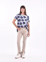 Remera de mangas cortas con estampado de flores abstractas en tonos azul y lila sobre fondo blanco.