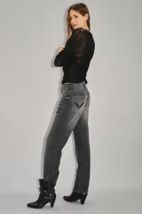 Jean de tiro alto con corte recto, confeccionado en denim rígido de color negro. Presenta un diseño clásico con cierre y botón, bolsillos traseros con bordado de alas y ruedo desarmado.